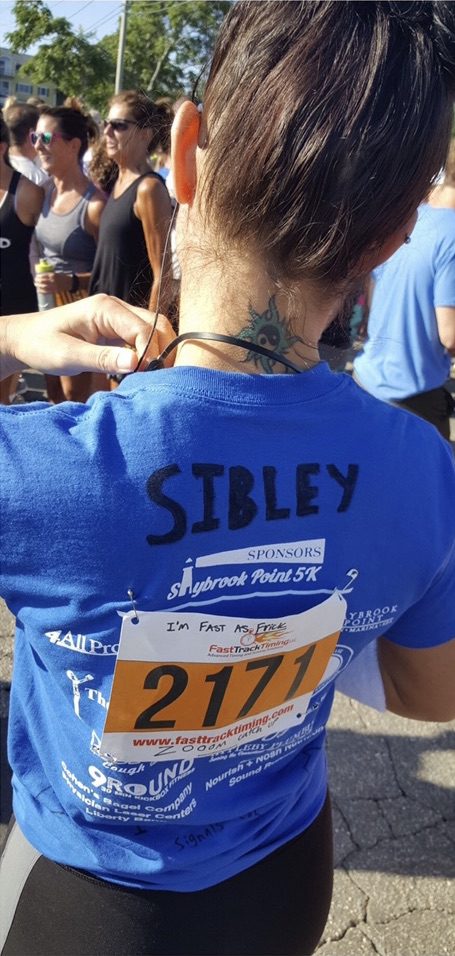 Back of a woman's blue shirt after a race